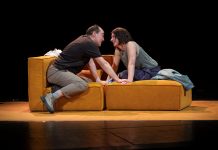 Liebe geht raus Markus Seuß und Petra-Janina Schultz sitzen zu sich gegenseitig vorgelehnt auf einem Sofa auf der Theaterbühne